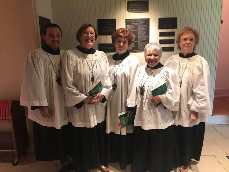 A man and four women in choir dress.
